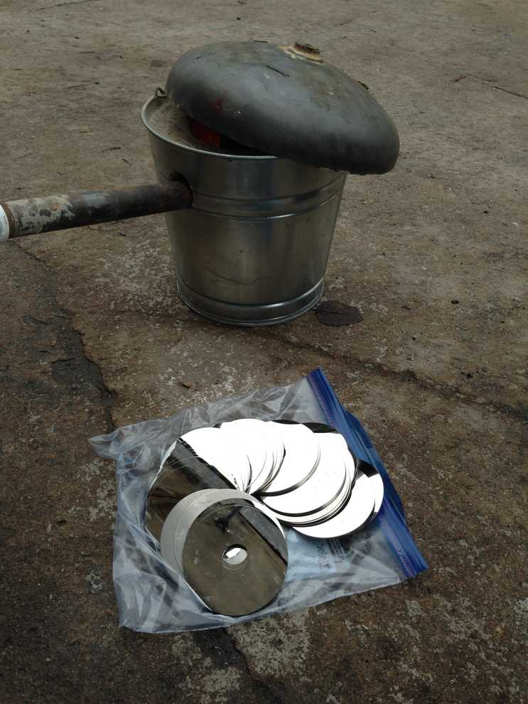 Hard drive platters sitting next to an aluminum forge